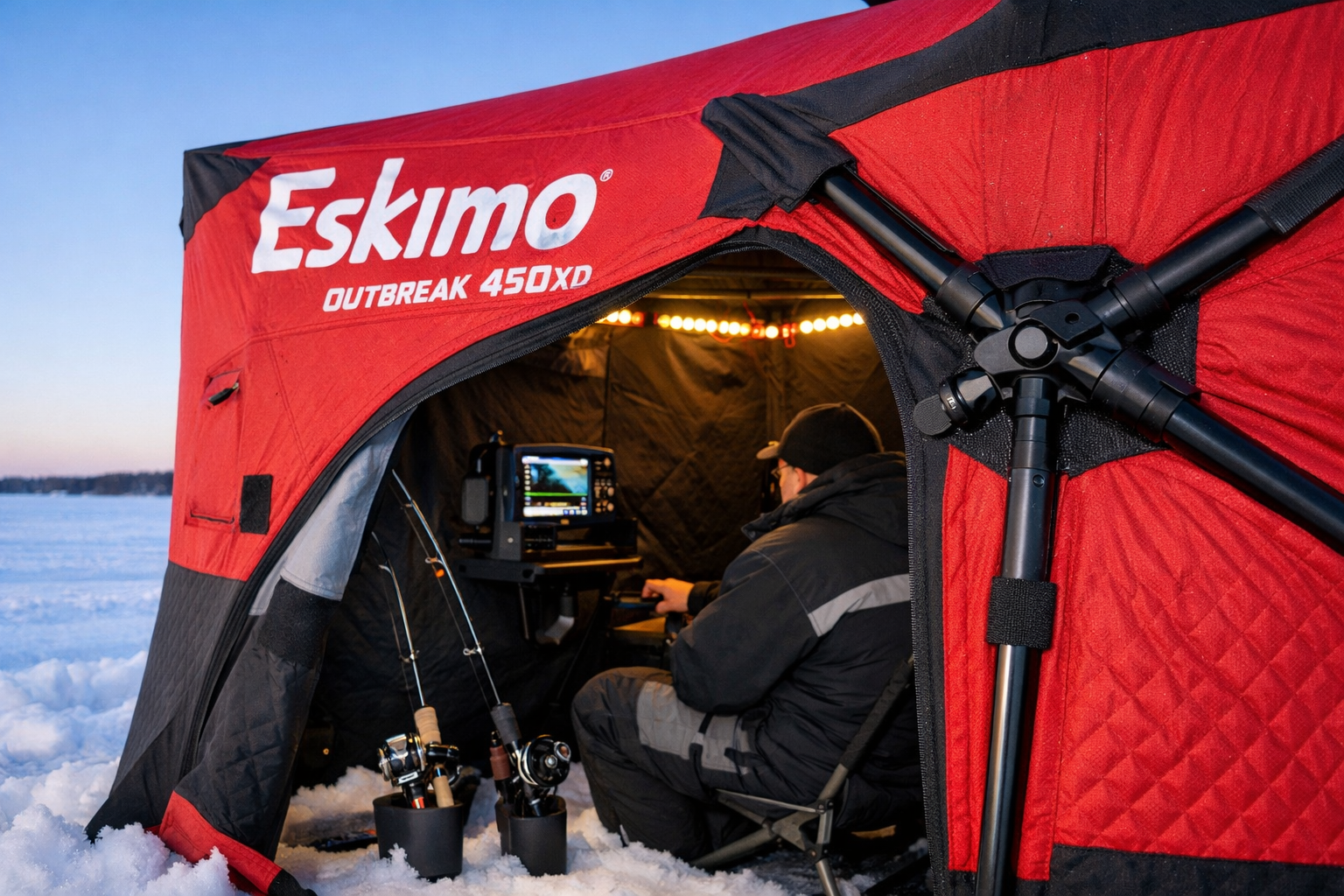 Detailed () showing a close-up view of an Eskimo Outbreak 450XD hub shelter fully deployed on a frozen lake with one angler